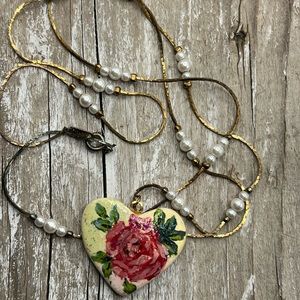 Gold tone faux pearl and clay floral heart necklace. Chain is approx 29”